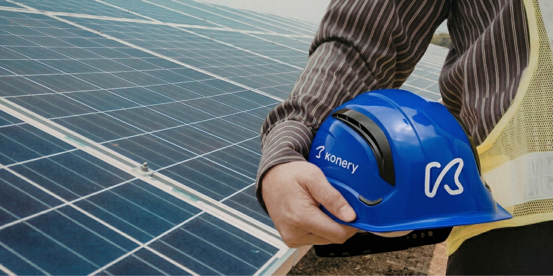 Técnico de mantenimiento con casco junto a una instalación de placas solares fotovoltaicas