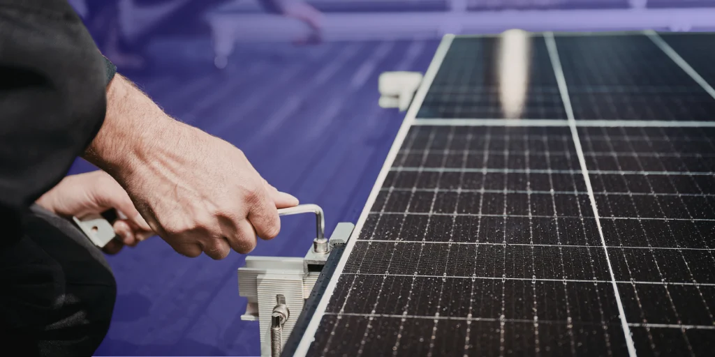 Técnico ajustando la estructura de un panel solar durante una revisión de mantenimiento